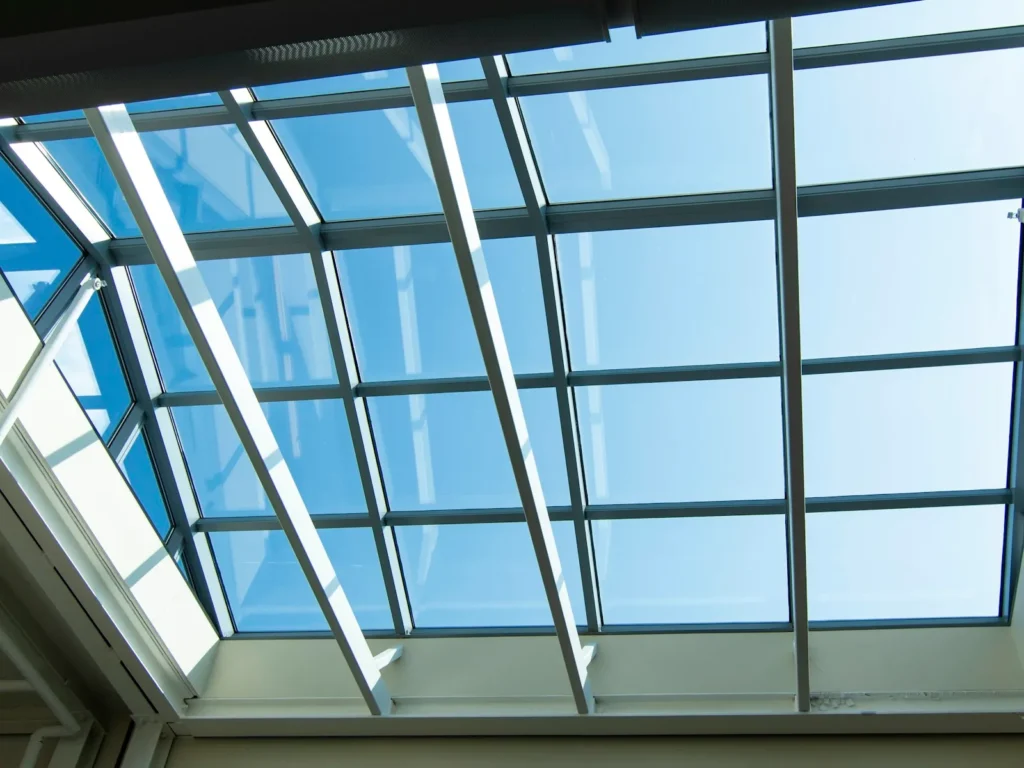 Glass skylight roof panels against a blue sky
