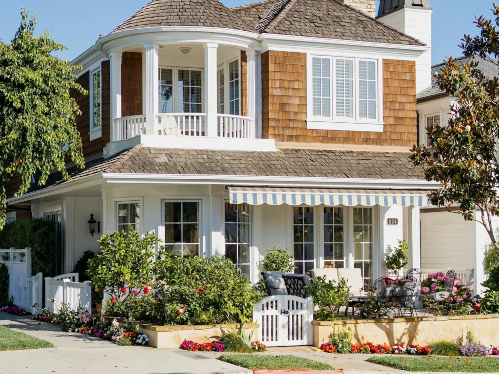 Two-story home with many windows, balcony and awnings